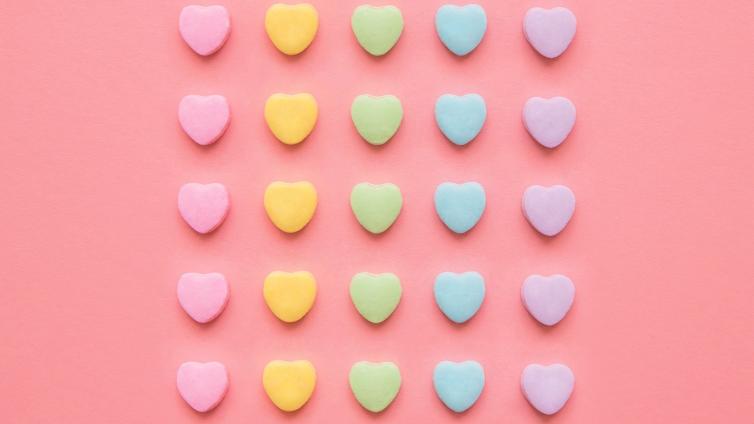 Rows of colorful hearts on a solid colored background